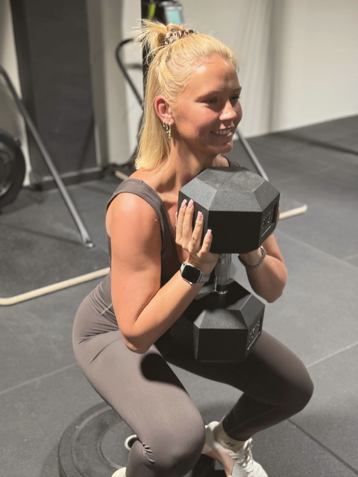 A member doing a goblet squat with a heavy dumbbell